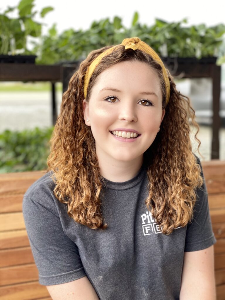 A woman with a yellow headband sitting on a bench. 