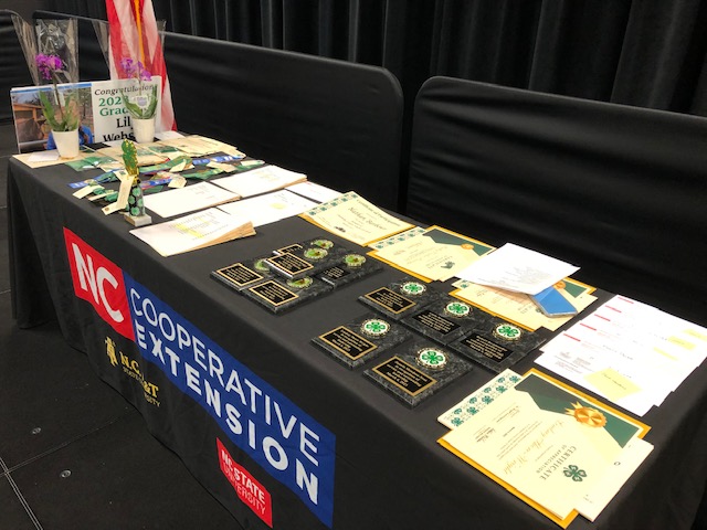 An N.C. Cooperative Extension Table with awards, trophies and certificates. 