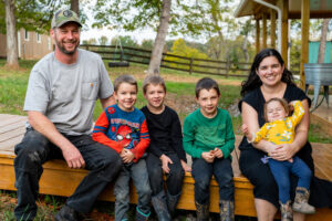 A family poses together on a farm.